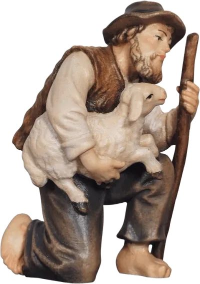 Hand-carved wooden shepherd kneeling holding a lamb, painted in natural colors
